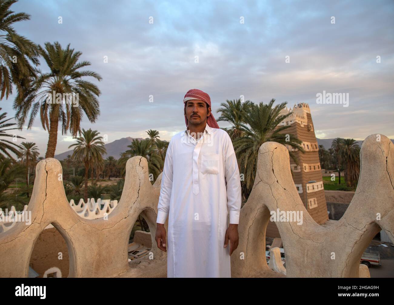 Uomo Saudita sulla terrazza delle sue tradizionali case di fango, provincia di Najran, Najran, Arabia Saudita Foto Stock