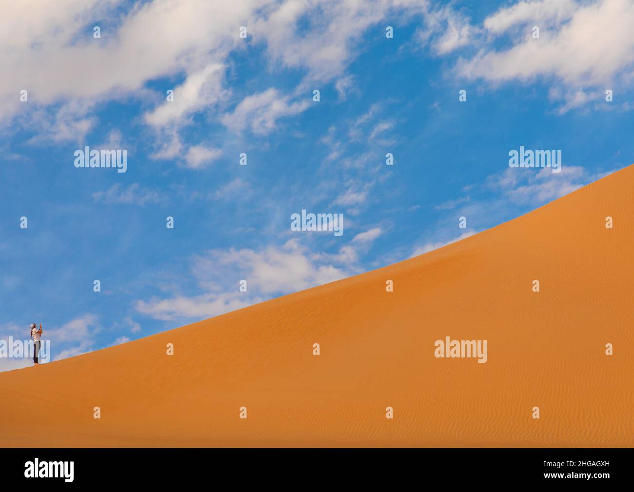 Turista fotografando ai piedi di una duna di Rub al Khali, provincia di Najran, Thar, Arabia Saudita Foto Stock