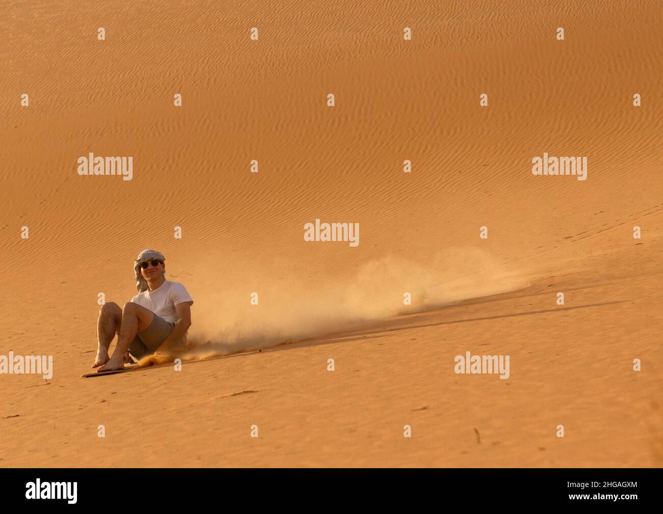 Turista che fa sandboarding nel deserto delle dune di Rub al Khali, provincia di Najran, Thar, Arabia Saudita Foto Stock