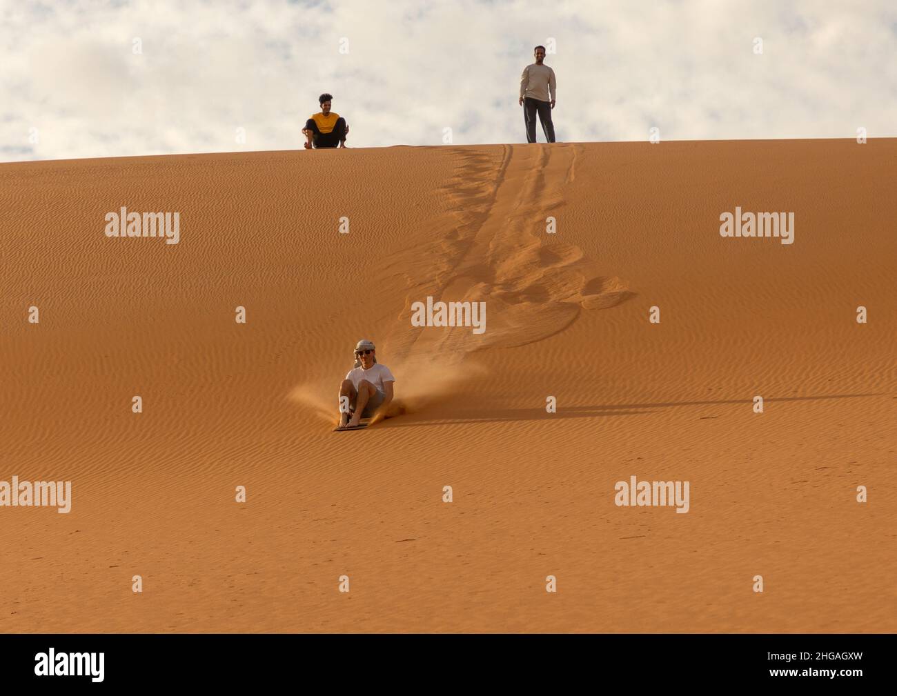 Turista che fa sandboarding nel deserto delle dune di Rub al Khali, provincia di Najran, Thar, Arabia Saudita Foto Stock