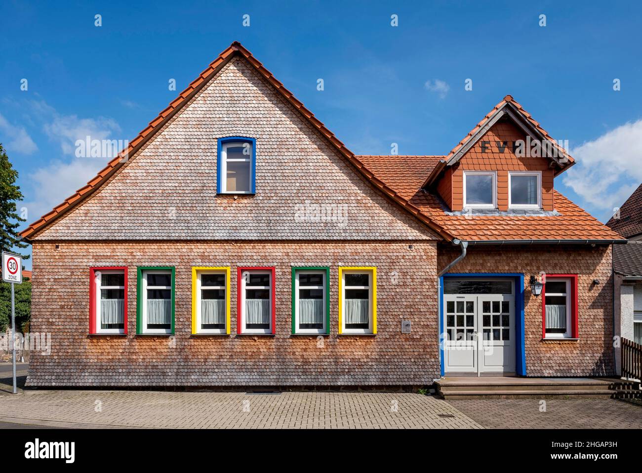 Casa ristrutturata in legno di scandole, finestre in diversi colori all'interno, Alte Kinderschule, Herbstein, Vogelsberg, Hesse, Germania Foto Stock