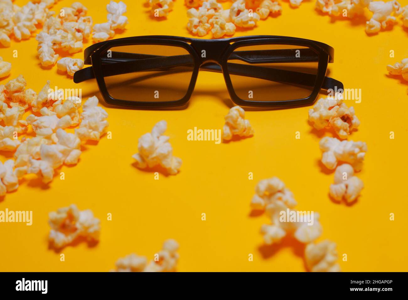 Sessione cinematografica, film, popcorn, 3D bicchieri. Guarda film concept, cinema, sconti. Sfondo giallo del cinema. Occhiali per film 3D in popcorn. Foto Stock