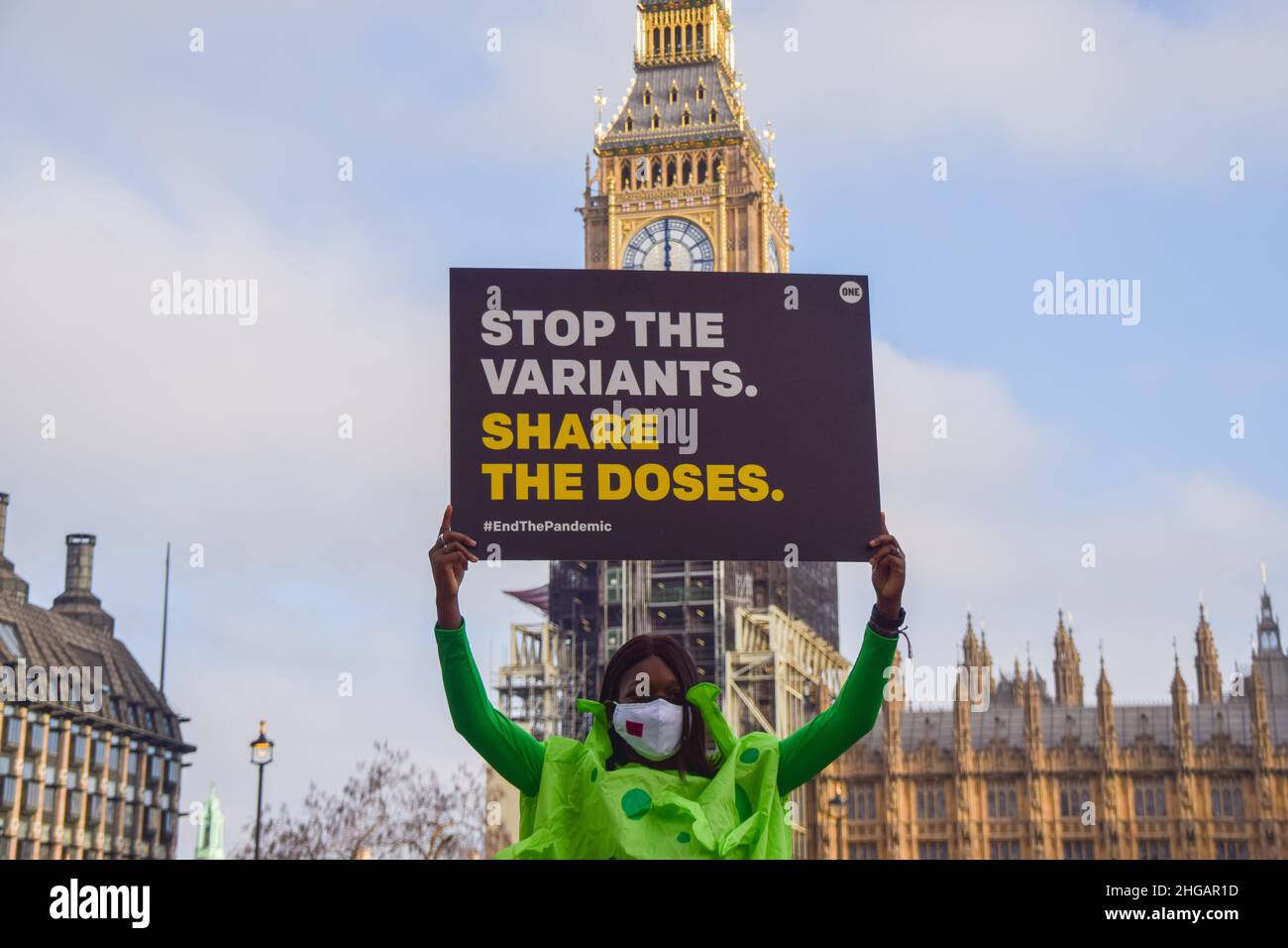 Londra, Regno Unito. 18th Jan 2022. Un attivista che indossa un costume da coronavirus ha in mano un cartello che invita il governo del Regno Unito a condividere i vaccini durante la campagna di vaccinazione del mondo.gli attivisti di UN Regno Unito, un movimento globale che lavora per porre fine alla povertà estrema e alle malattie prevenibili entro il 2030, hanno organizzato una campagna con costumi da coronavirus e medici in Piazza del Parlamento, Chiedere al governo britannico e ai leader mondiali di condividere i vaccini con i paesi a basso reddito, vaccinare il mondo e porre fine alla pandemia del COVID-19. Credit: SOPA Images Limited/Alamy Live News Foto Stock