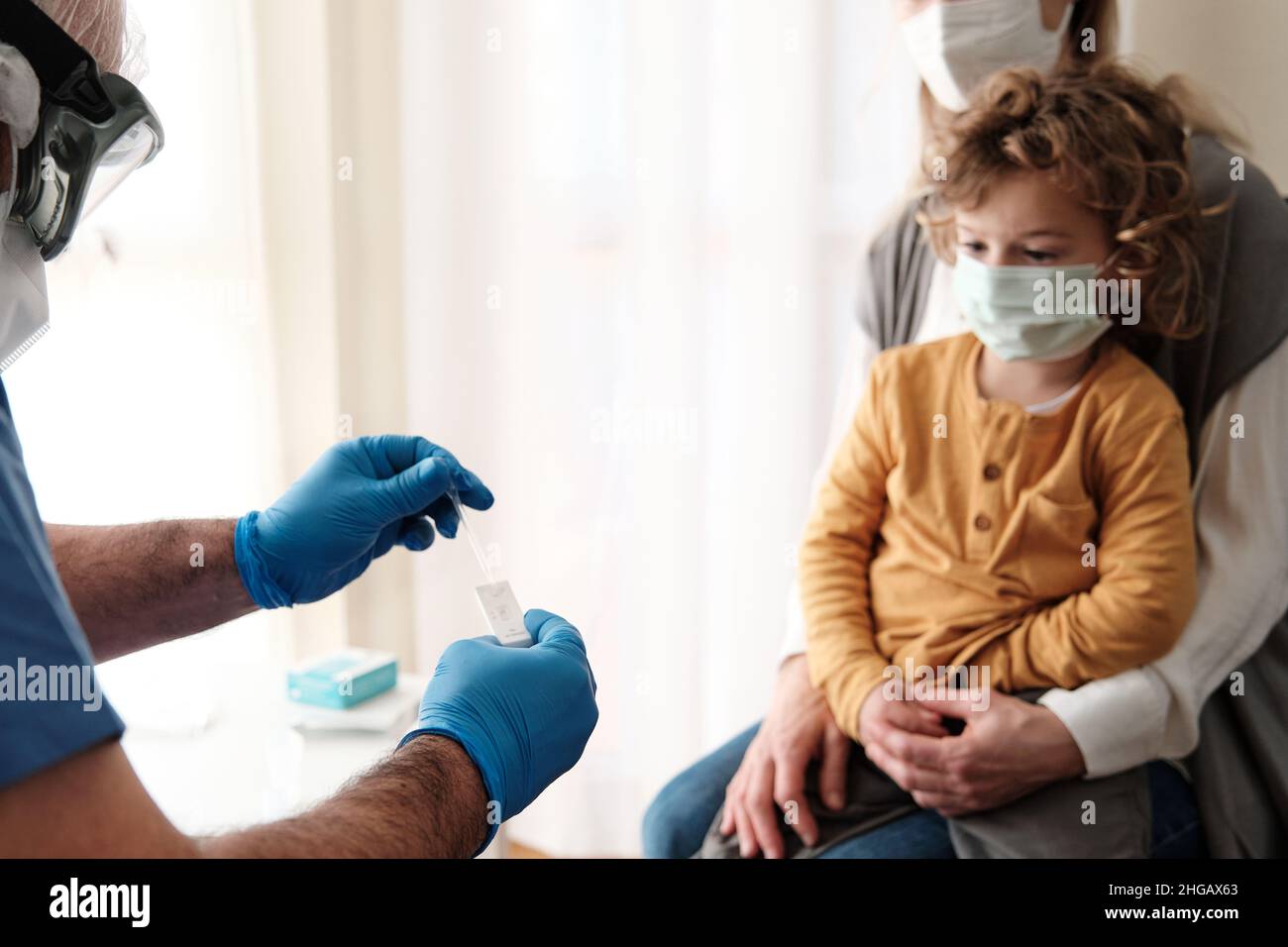Un infermiere che esegue un test dell'antigene su un bambino giovane Foto Stock