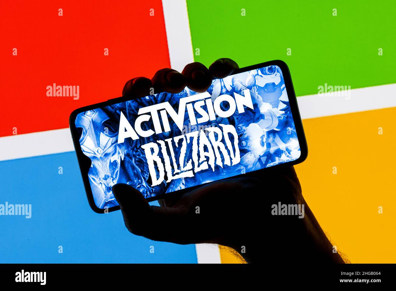 Logo Activision Blizzard sullo schermo dello smartphone in mano sullo sfondo del logo Microsoft. Foto Stock