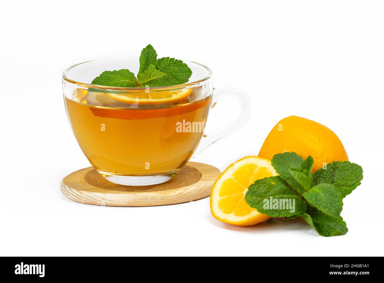 Tazza di vetro trasparente con tè aromatico, foglie di menta e fetta di limone isolato su sfondo bianco. Parte del set. Foto Stock