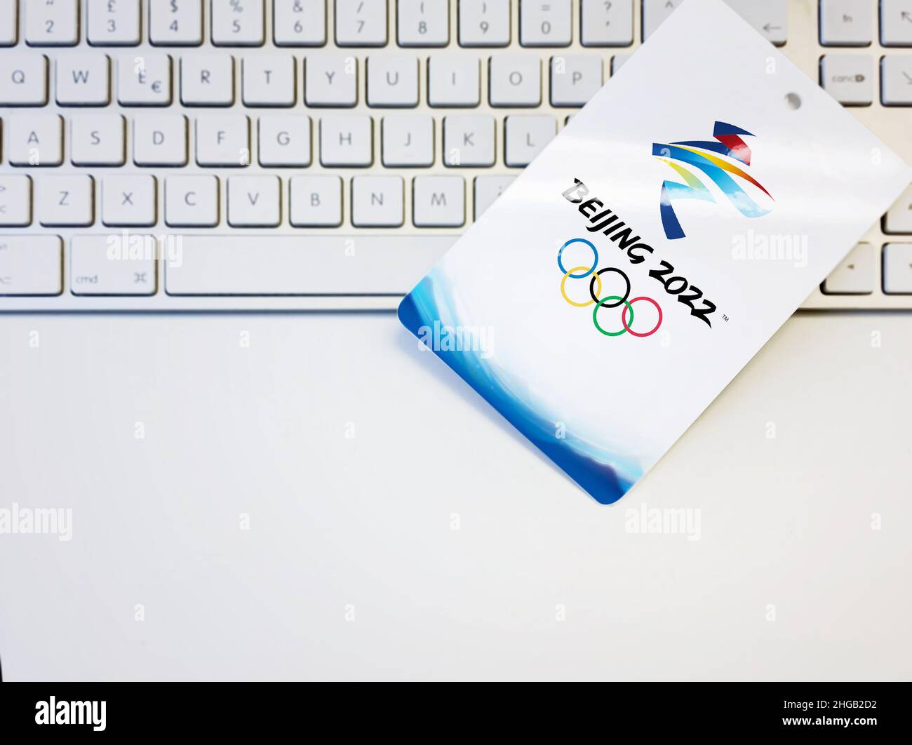 Pechino, Cina, ottobre 2021: Badge bianco vuoto con l'illustrazione del logo dei giochi olimpici invernali di Pechino 2022 su una tastiera per computer. Evento internazionale. Foto Stock