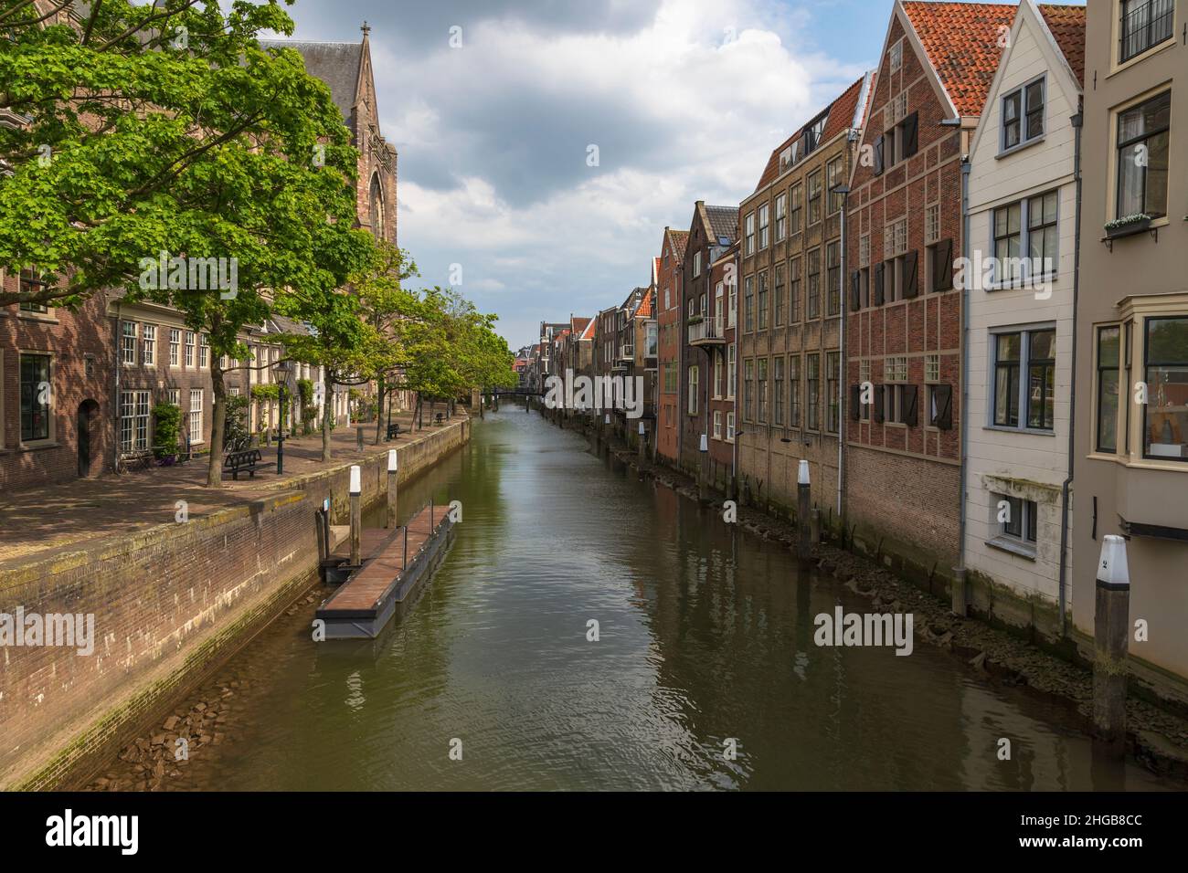 Canale d'acqua tra case con percorso lungo case a Dordrecgt in Olanda. La strada è fiancheggiata da alberi. Foto Stock