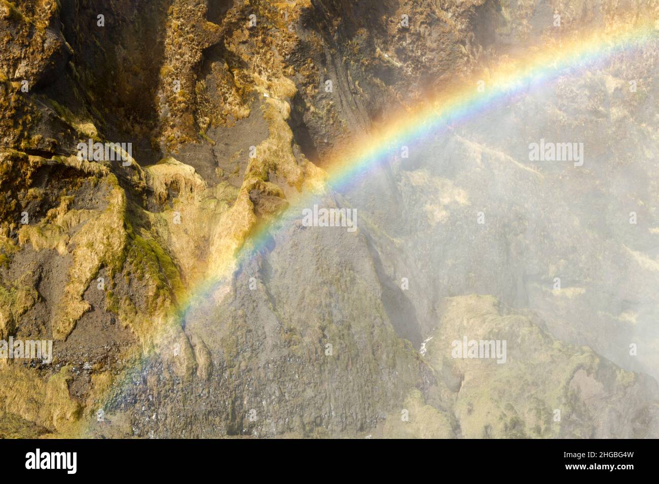 Rainbow creato nel getto d'acqua alla cascata di Skogafoss in Islanda Foto Stock