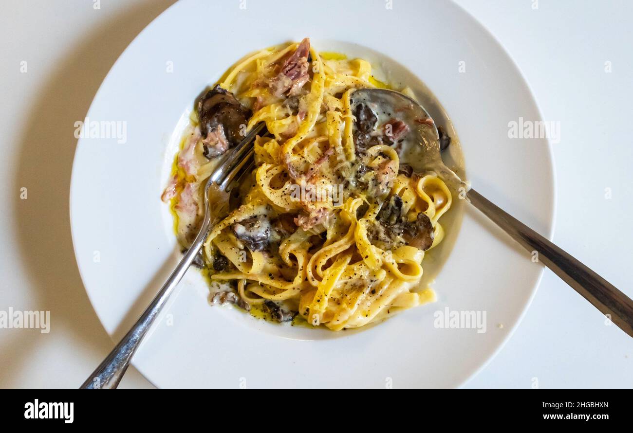 Tagliatelle con salsa cremosa di funghi e prosciutto cotto Foto Stock