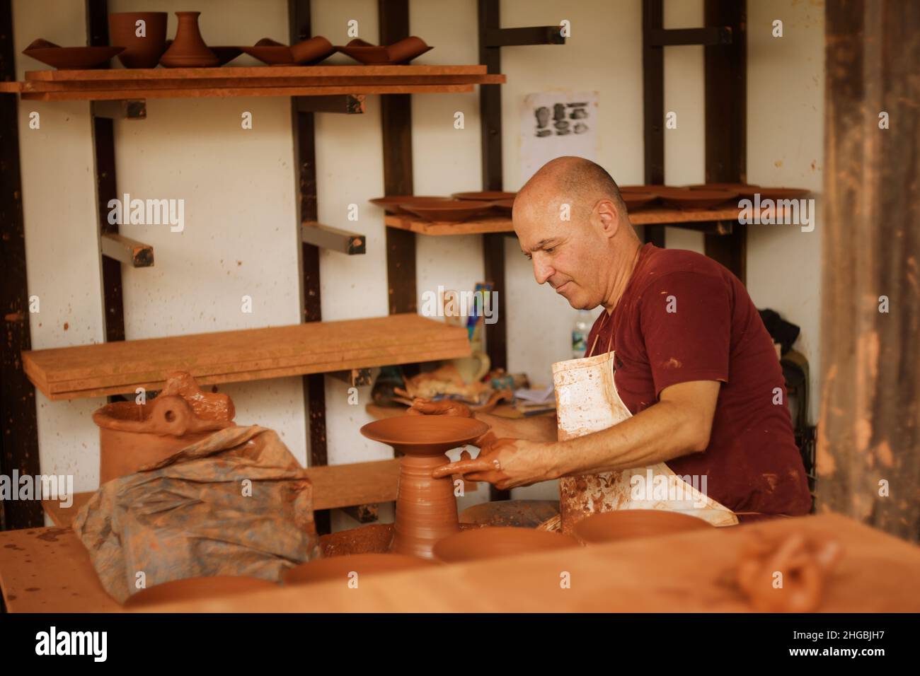 Spagnolo, Tenerife 16.09.2019 un uomo scolpito da argilla. Un uomo scolpisce argilla, piatti, tazze, mestoli. Foto Stock