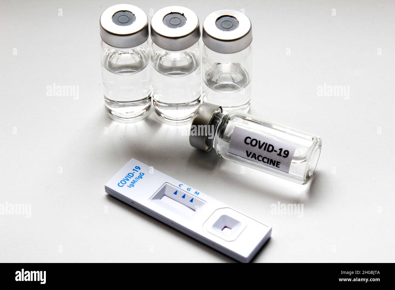 Cassetta per test diagnostico con antigene rapido di Coronavirus SARS-COV-2 Covid-19 e fiale con vaccino su sfondo bianco Foto Stock