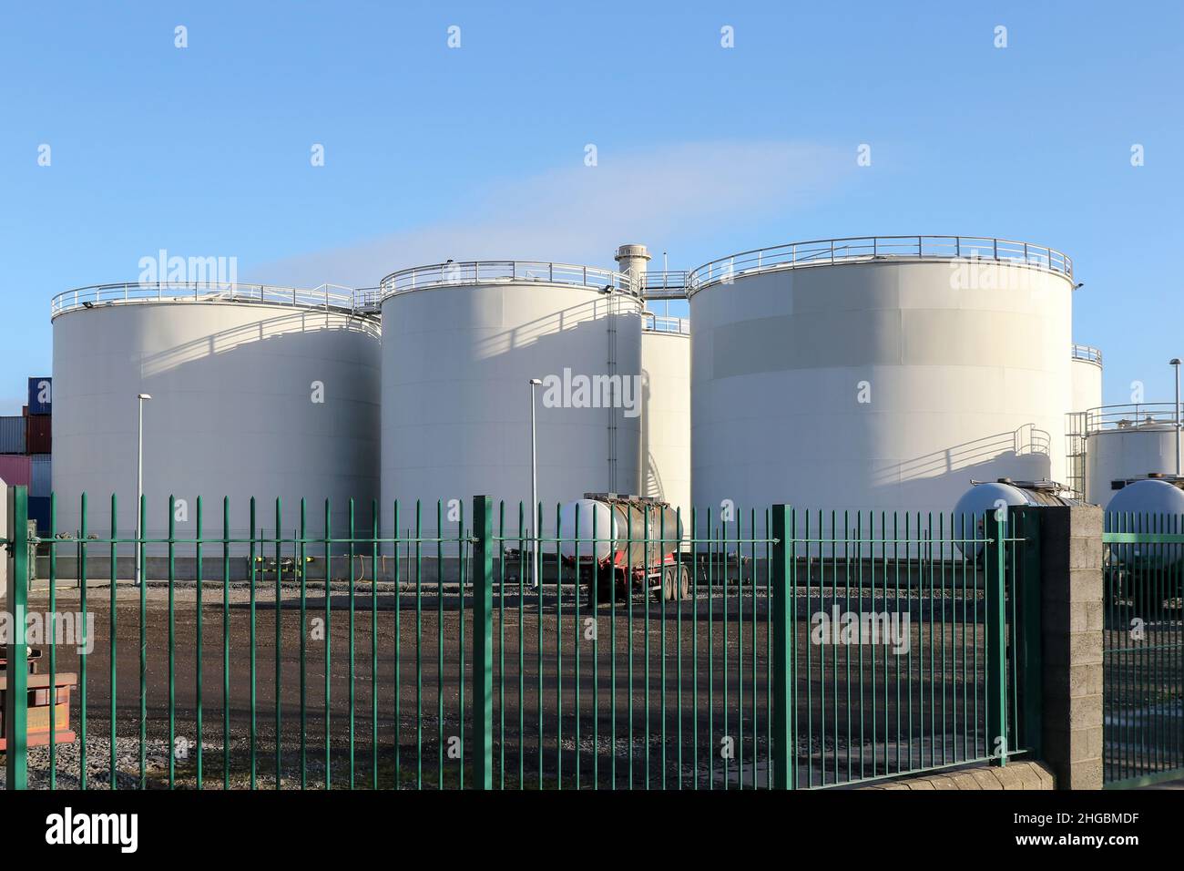 Serbatoi di stoccaggio del carburante a olio bianco contro il cielo blu. Tamburi circolari in acciaio nei docklands. Dublino, Irlanda Foto Stock