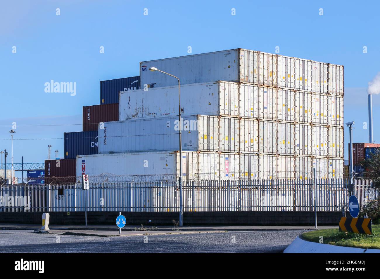 Impilamento di casse di spedizione bianche con disposizione a gradini con modello lineare. Contenitori blu e marrone oltre. Industria di trasporto al porto. Dublino, Irlanda Foto Stock