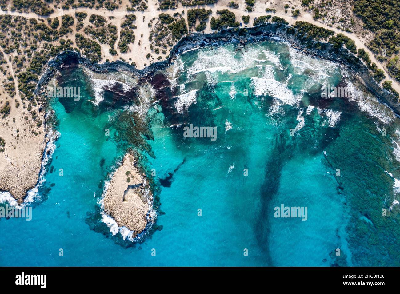 Vista dall'alto di uno splendido porto marittimo. Laguna con acqua turchese. Onde vicino costa rocciosa Foto Stock