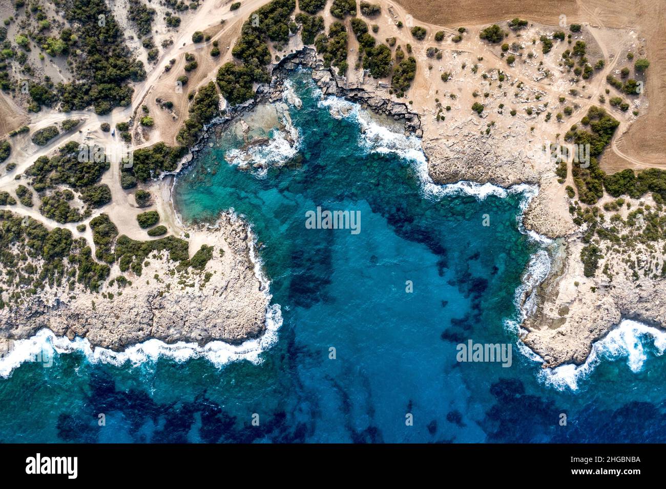 Vista dall'alto di uno splendido porto marittimo. Laguna con acqua turchese. Onde vicino costa rocciosa Foto Stock