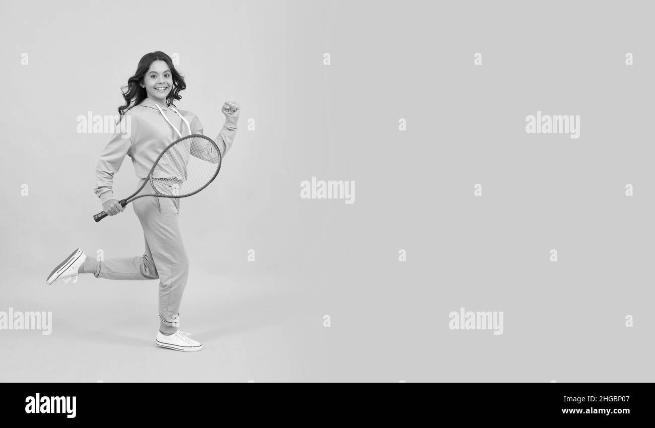 felice energico salto di ragazza teen con racchetta badminton in esecuzione al successo, copia spazio, pieno di energia Foto Stock