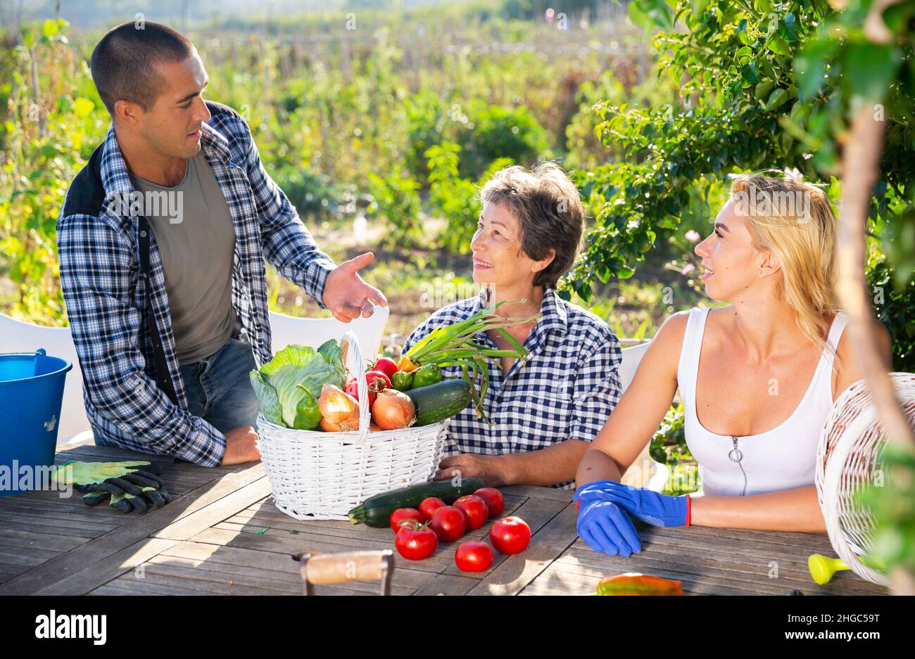 Mamma con i bambini adulti gioisce per la raccolta di verdure Foto Stock