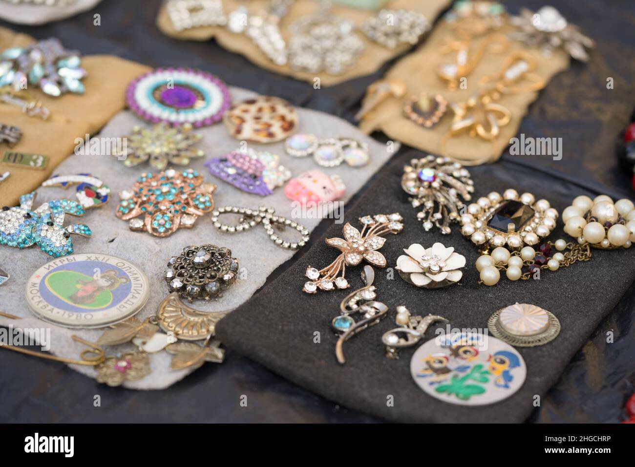 Lviv, Ucraina - 16 gennaio 2022 : Antiquariato sul mercato delle pulci - primo piano di gioielli d'epoca, spille d'argento, badge d'epoca. Oggetti da collezione Foto Stock
