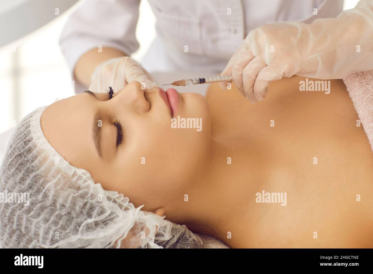 Donna che ottiene un'iniezione per le labbra plump in una clinica di medicina estetica Foto Stock