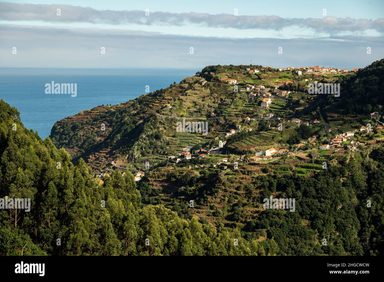 Vista panoramica delle case del villaggio di Ribeira da Janela e del paesaggio terrazzato circostante, vista dal sentiero escursionistico “Levada da Ribeira da Janela” Foto Stock
