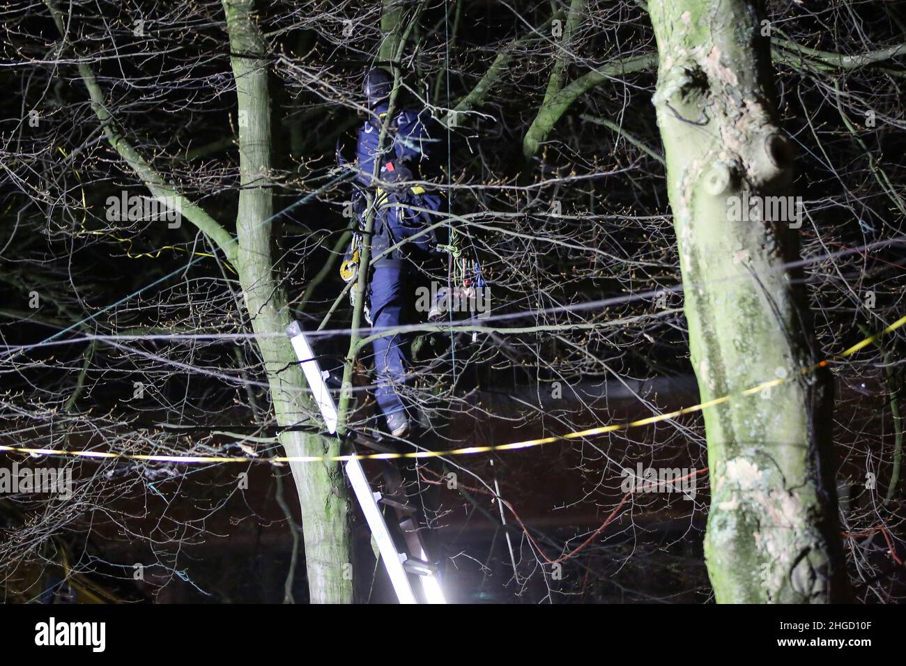 Amburgo, Germania. 20th Jan 2022. Un poliziotto si erge su una scala da un albero precedentemente occupato. Gli attivisti hanno protestato all'inizio del giovedì mattina contro la caduta di alberi a Neuer Pferdemarkt a St. Pauli. Tre persone erano salite negli alberi per impedire il lavoro di abbattimento, ha detto la polizia. Inoltre, molti altri attivisti si erano riuniti nel sito. Credit: Bodo Marks//dpa/Alamy Live News Foto Stock