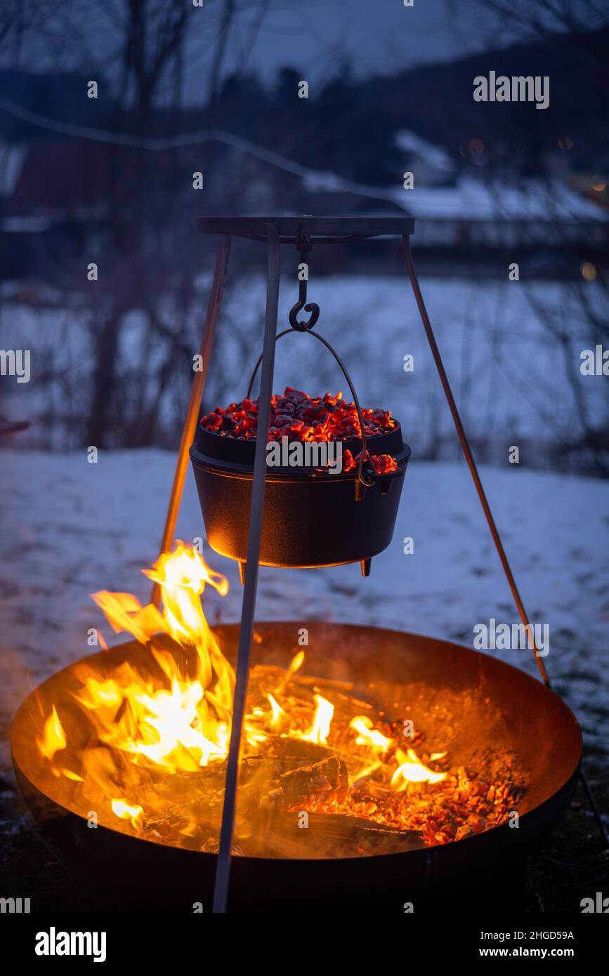 cucinare un forno olandese sul fuoco in inverno Foto Stock