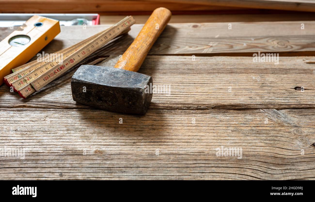 Martello a slitta vecchio usato con impugnatura in legno su legno, spazio copia. Industria edile, tavolo da lavoro da carpentiere con utensili vintage Foto Stock