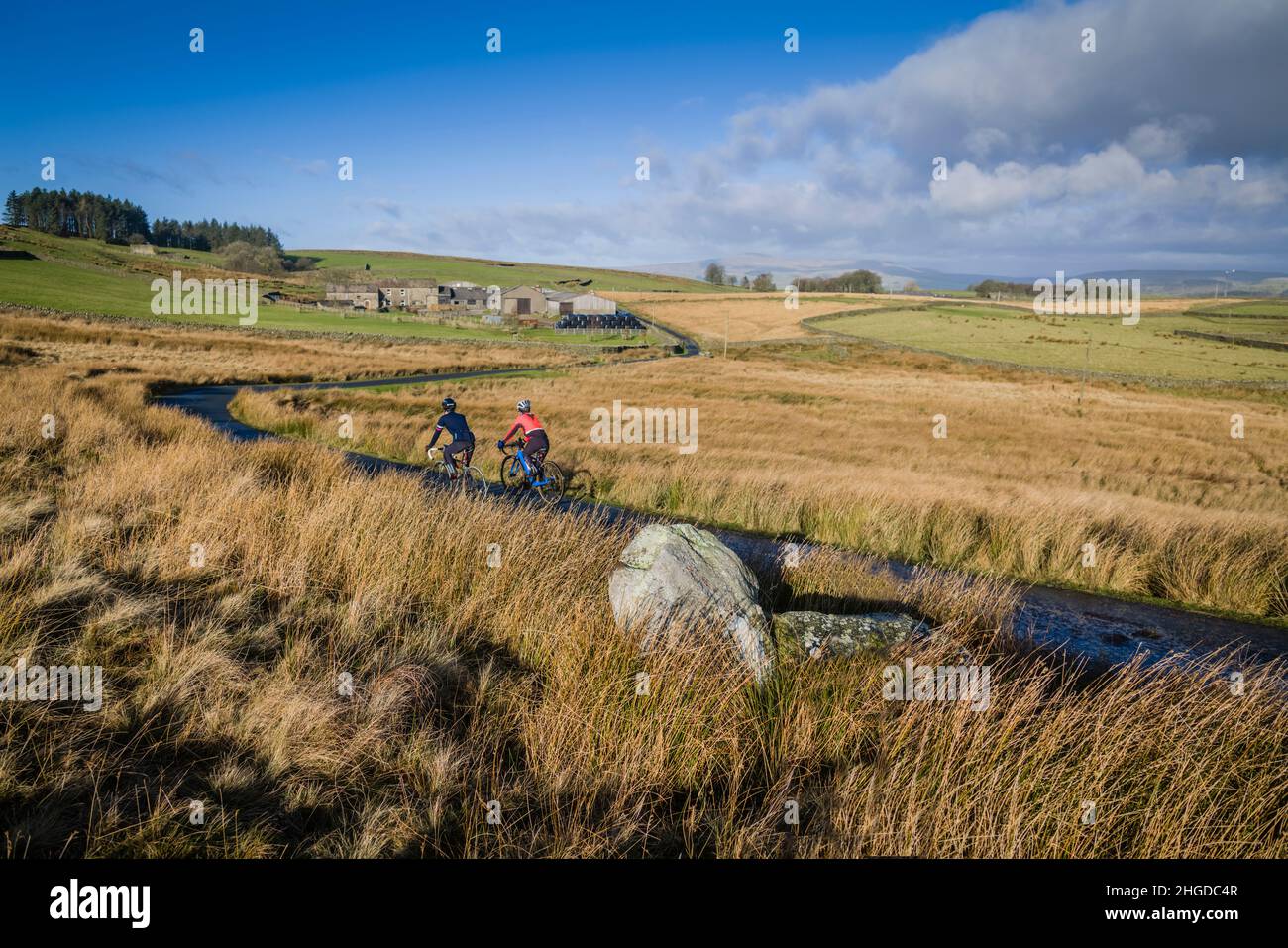 Madre e figlio pedalano su strade tranquille nella zona di Bowland, Lancashire, Regno Unito. Foto Stock