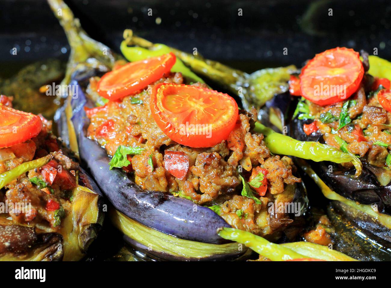 Il Karniyarik (Karnıyarık) è un classico piatto turco popolare. Karniyarik è una melanzana farcita con carne tritata con cipolle fritte, aglio, pomodori, piselli Foto Stock