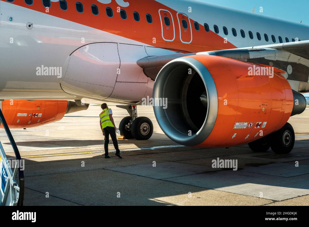 L'ingegnere dell'aviazione ispeziona l'aeroplano Easyjet tra le luci di linea, London Gatwick Airport, England Foto Stock