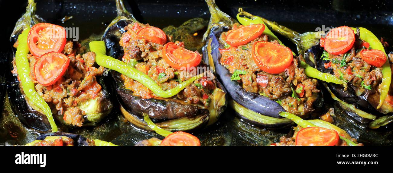 Il Karniyarik (Karnıyarık) è un classico piatto turco popolare. Karniyarik è una melanzana farcita con carne tritata con cipolle fritte, aglio, pomodori, piselli Foto Stock
