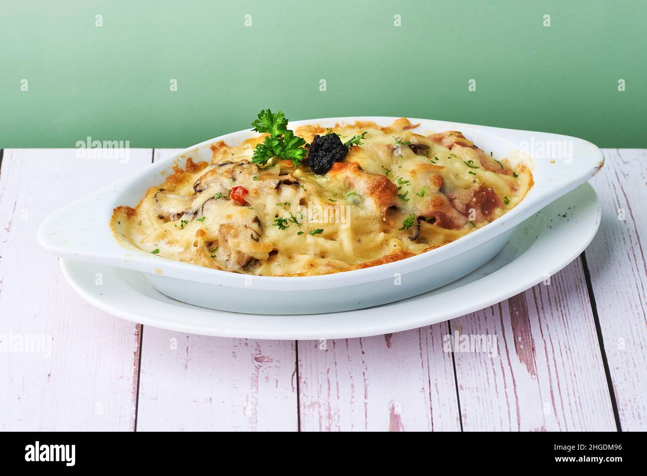 Crema di tartufo di pasta al forno con formaggio, olive, pasta, pollo e verdure gratinate in piatto da forno Foto Stock