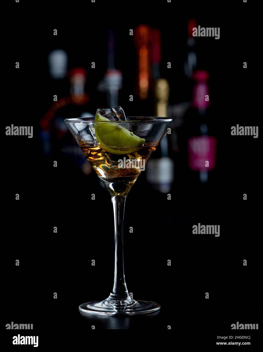 Cocktail Martini davanti a bottiglie sfocate Foto Stock