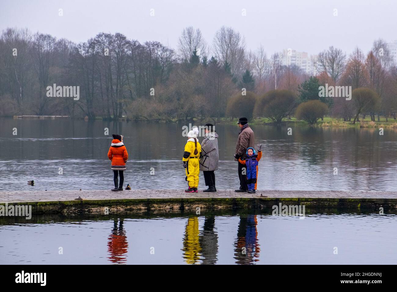 Nonni e loro nipoti passeggiando nel parco vicino al lago in autunno. Minsk. Bielorussia Foto Stock