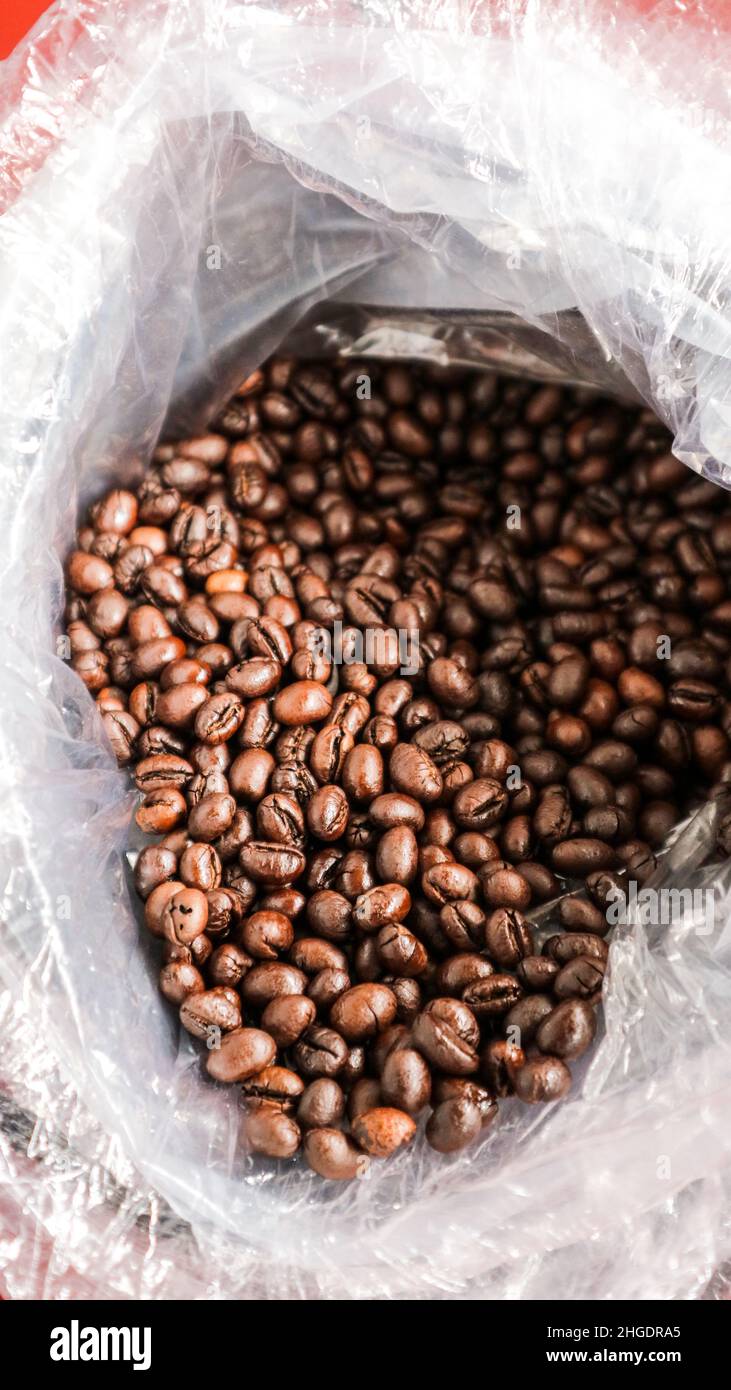 I chicchi di caffè tostati vengono ancora avvolti in cracker di caffè Foto Stock