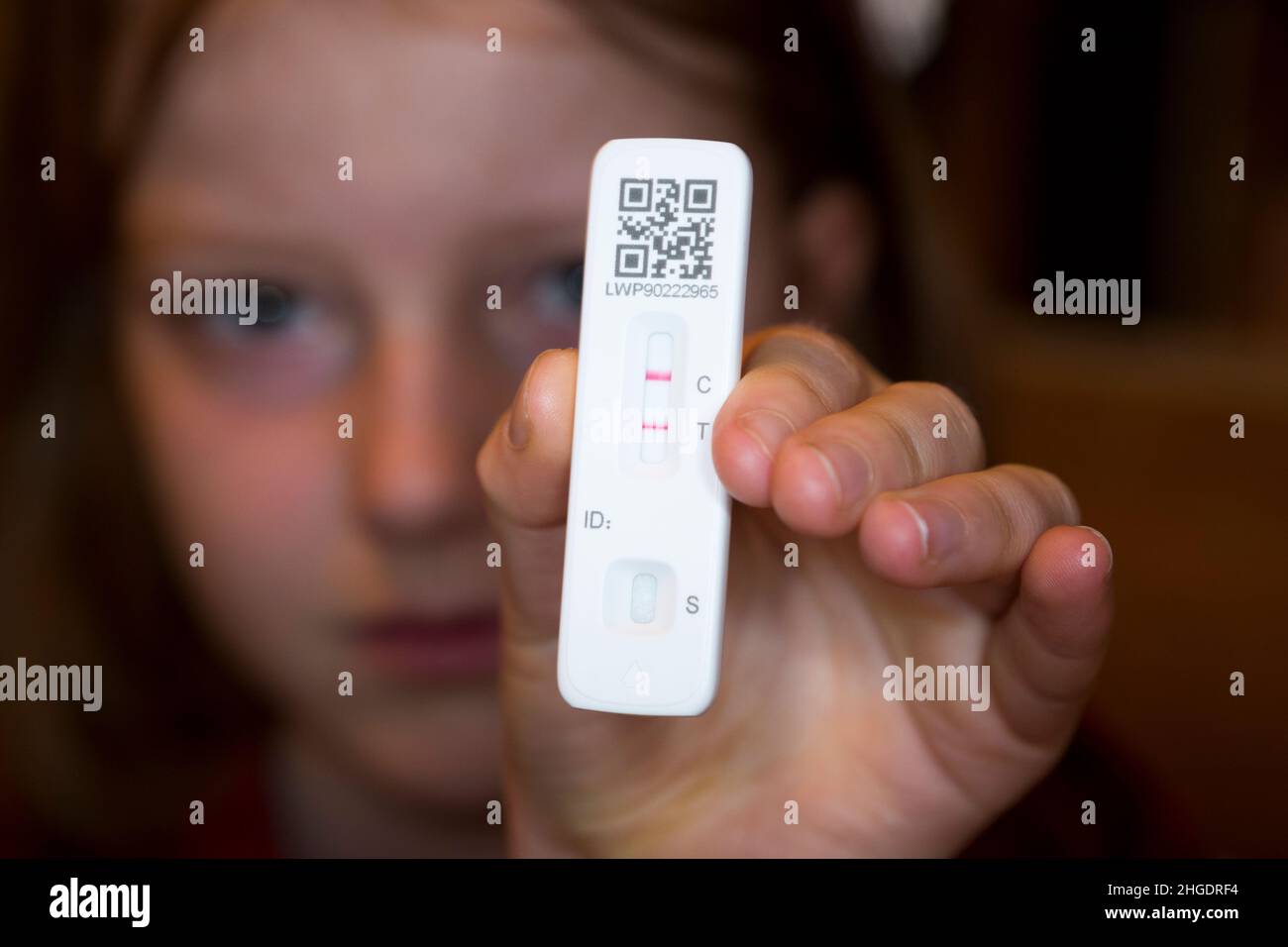 Undici anni / 11 anni anno 7 studente / bambino / bambino / ragazza che tiene il suo test di flusso laterale / LFT / LFD / Lateral flow device kit dopo aver provato positivo (mostrando due linee rosse) per il coronavirus virus COVID 19 durante il test Antigen home, a Londra. REGNO UNITO. Il test di flusso cinese (condotto da Orient gene in Cina) ha rilevato virus nel campione di tampone nasale prelevato dal naso. (128) Foto Stock