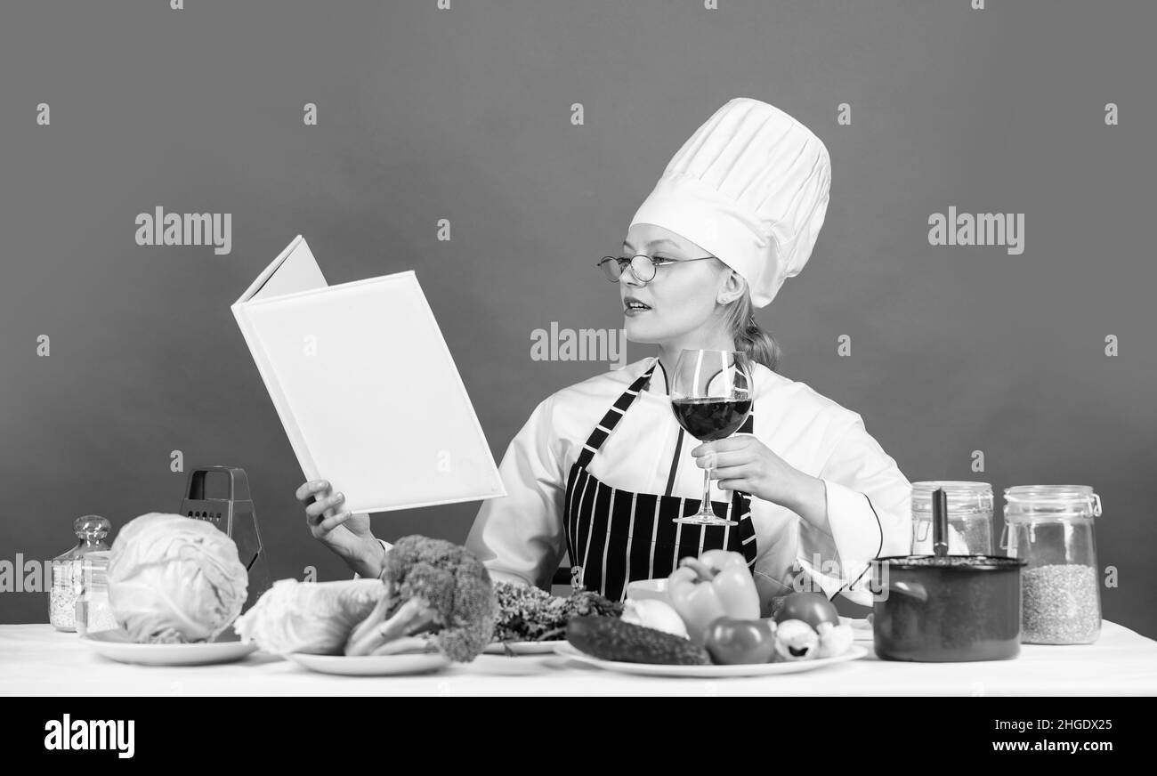 fai pratica di più. chef professionista che legge la ricetta per cucinare. cuoco femminile che prepara il piatto. cuoci in cucina. Apri il ricettario per una cucina sana Foto Stock