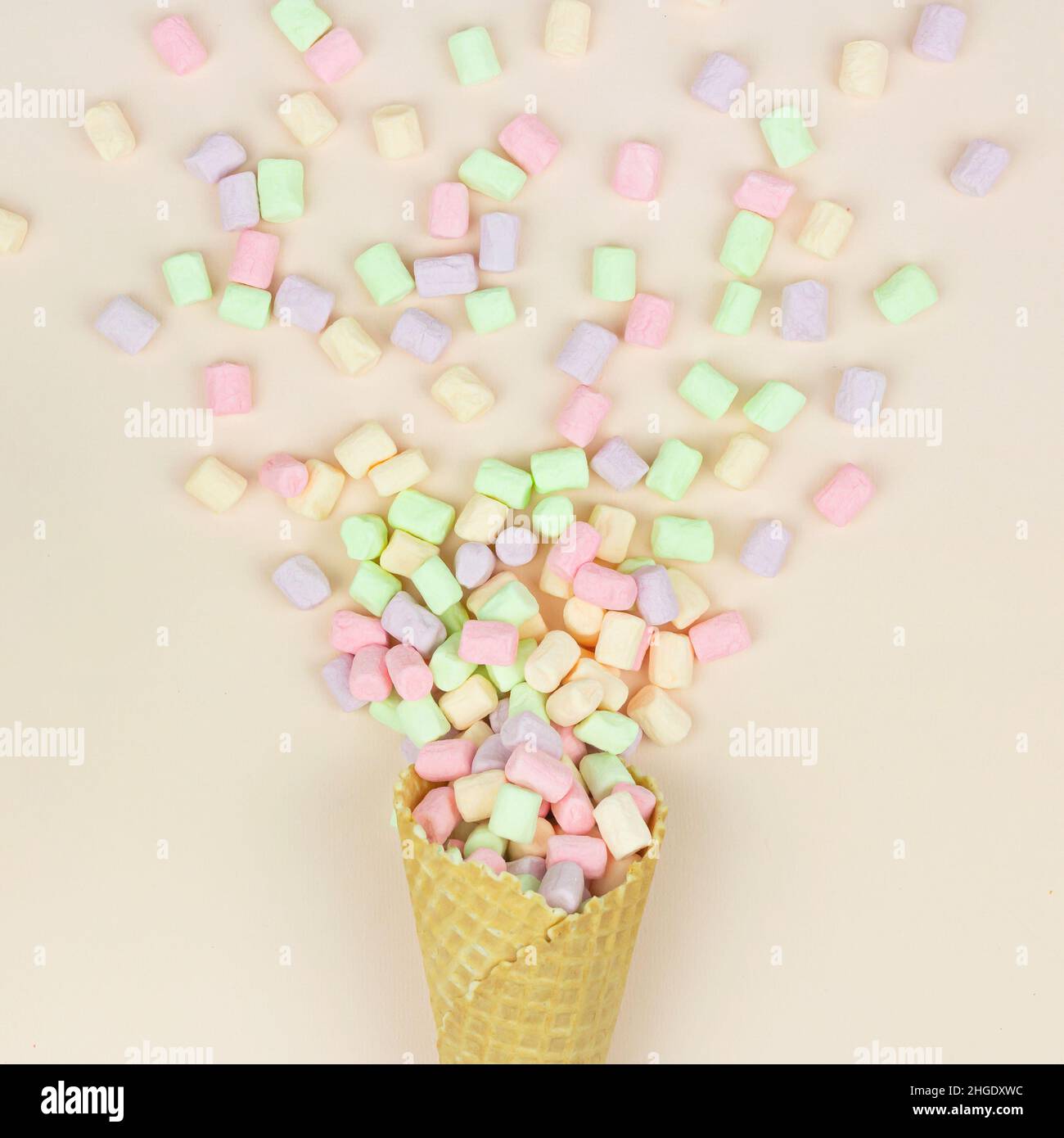 Marshmallows come fuochi d'artificio volare da un cono waffle su uno sfondo rosa. Concetto minimo creativo e moody Foto Stock