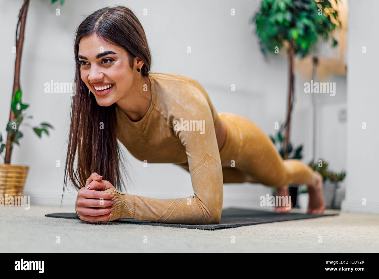 Fit, attiva e attraente giovane donna ragazza che si allunga prima o dopo l'esercizio a casa mantenendo sano e in forma modo di vita e il fisico quotidiano Foto Stock