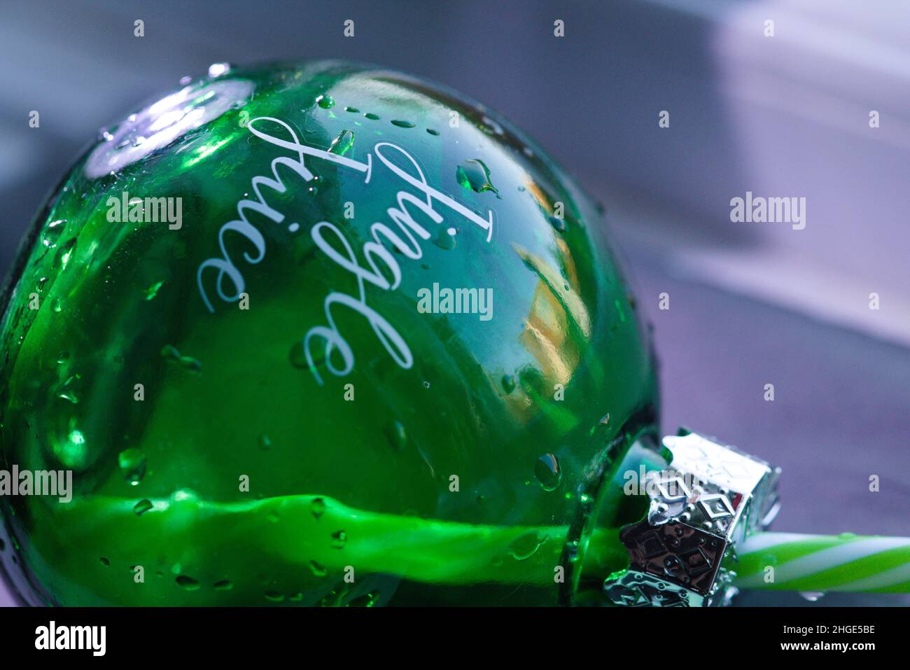 Primo piano di un Bauble in vetro verde umido con decalcomania "Jingle Juice" Foto Stock