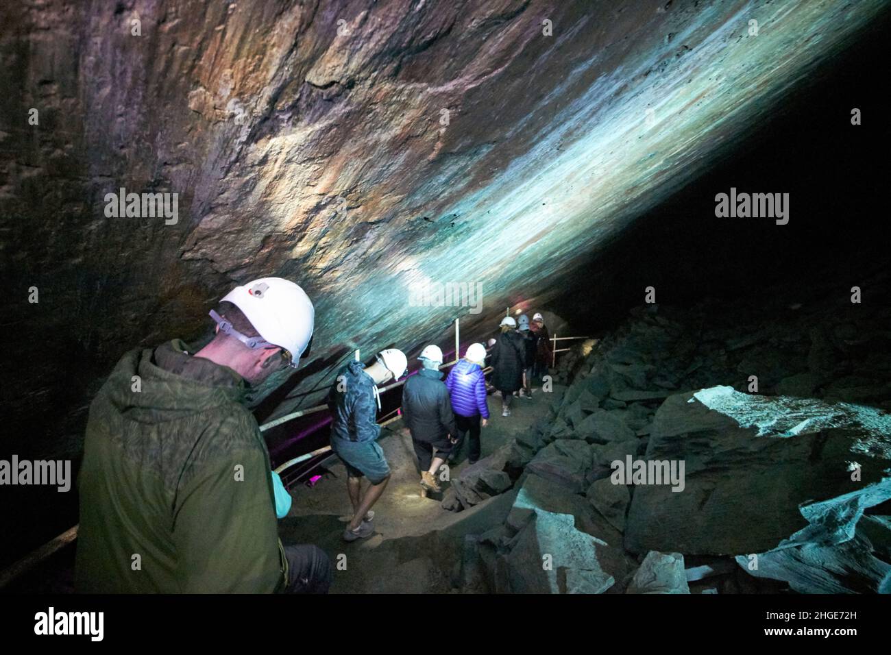 i turisti in visita guidata camminano lungo ripidi gradini all'interno del distretto del lago di honister slate, cumbria, inghilterra, regno unito Foto Stock