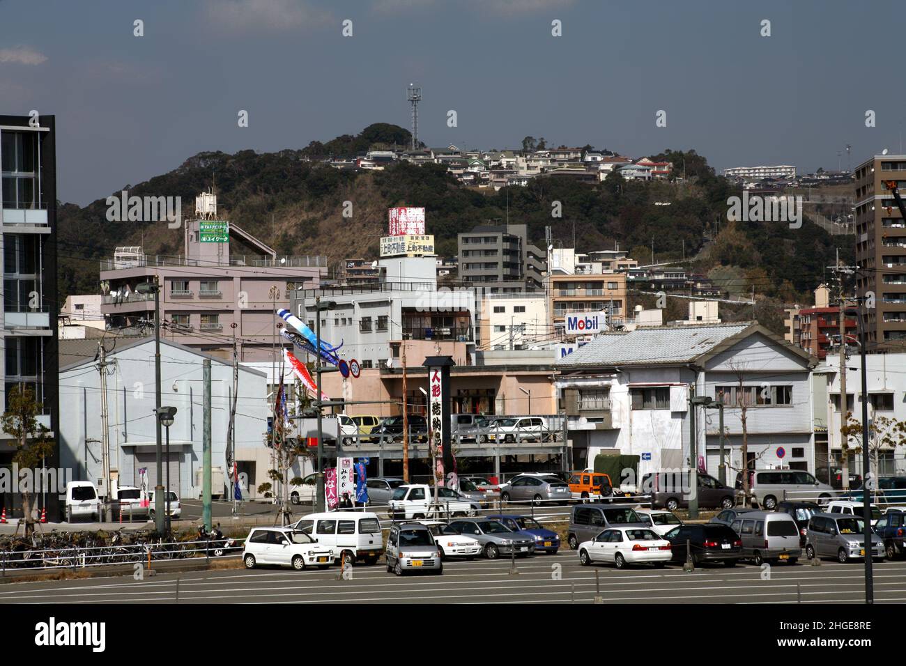 Il vulcano Sakurajima può essere visto in distanza attraverso la baia dalla città di Kagoshima Foto Stock