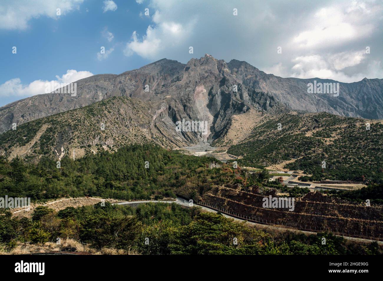 Il vulcano Sakurajima può essere visto in distanza attraverso la baia dalla città di Kagoshima Foto Stock