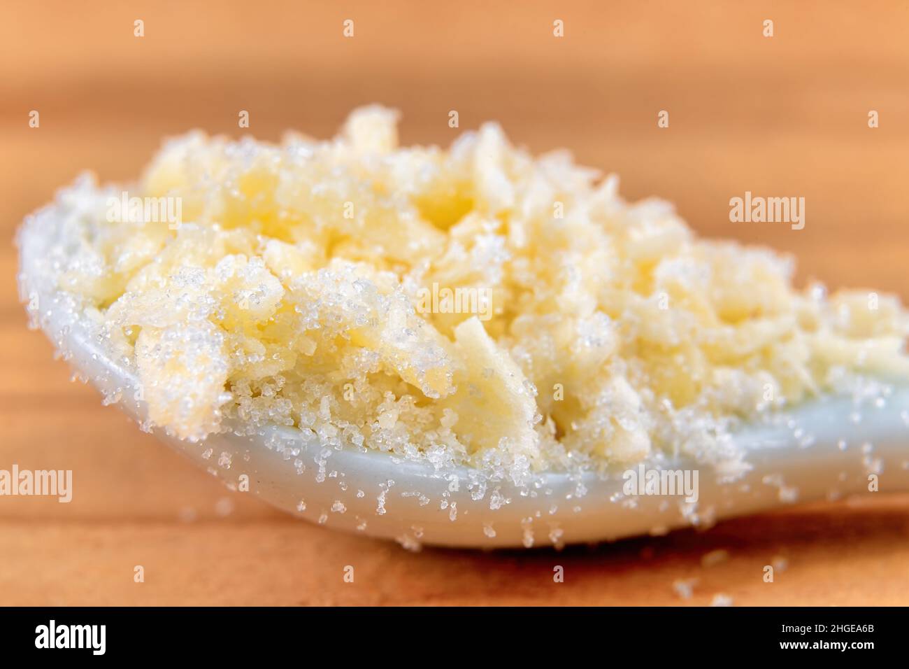 Piccoli pezzi di cocco grattugiato con zucchero bianco. Foto Stock