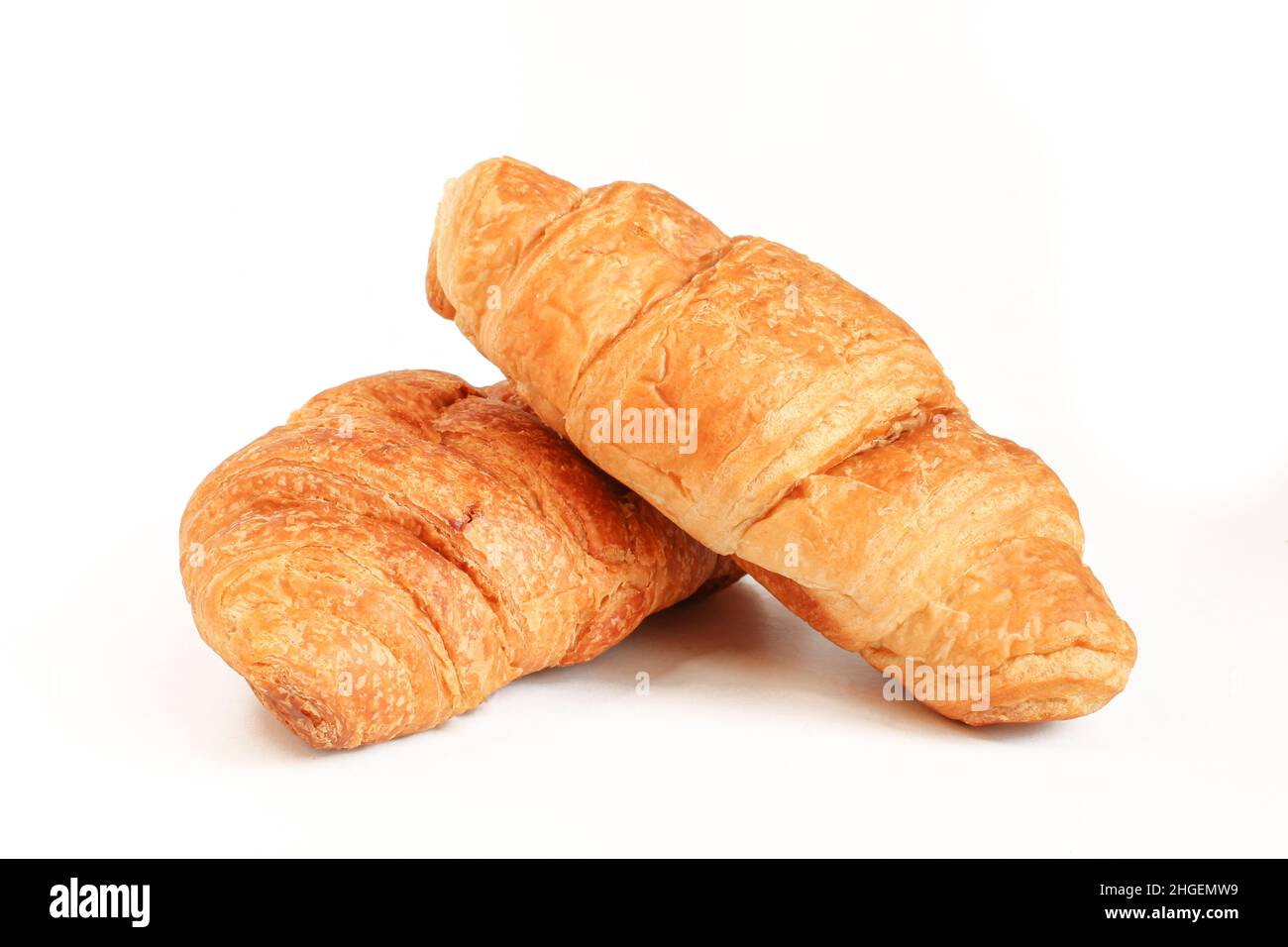 Due croissant isolati su sfondo bianco. Colore dorato Foto Stock