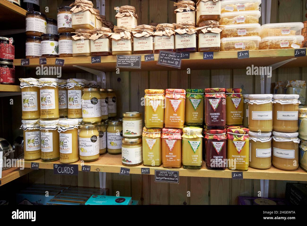 miele e curd in vendita in un negozio tradizionale nel distretto di lago di hawkshead village, cumbria, inghilterra, regno unito Foto Stock