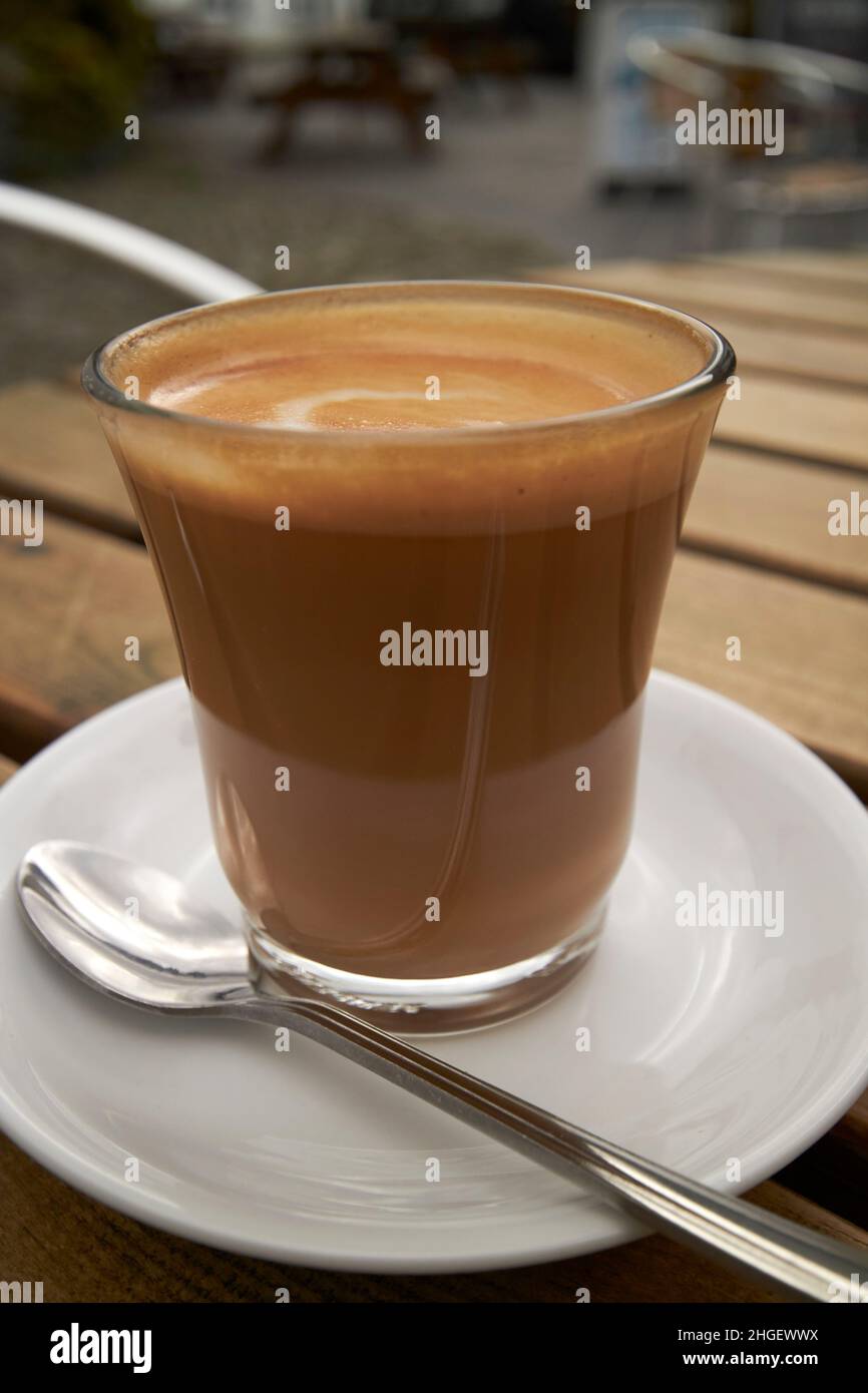 caffè bianco piatto su un tavolo da caffè all'aperto hawkshead lake district, cumbria, inghilterra, regno unito Foto Stock