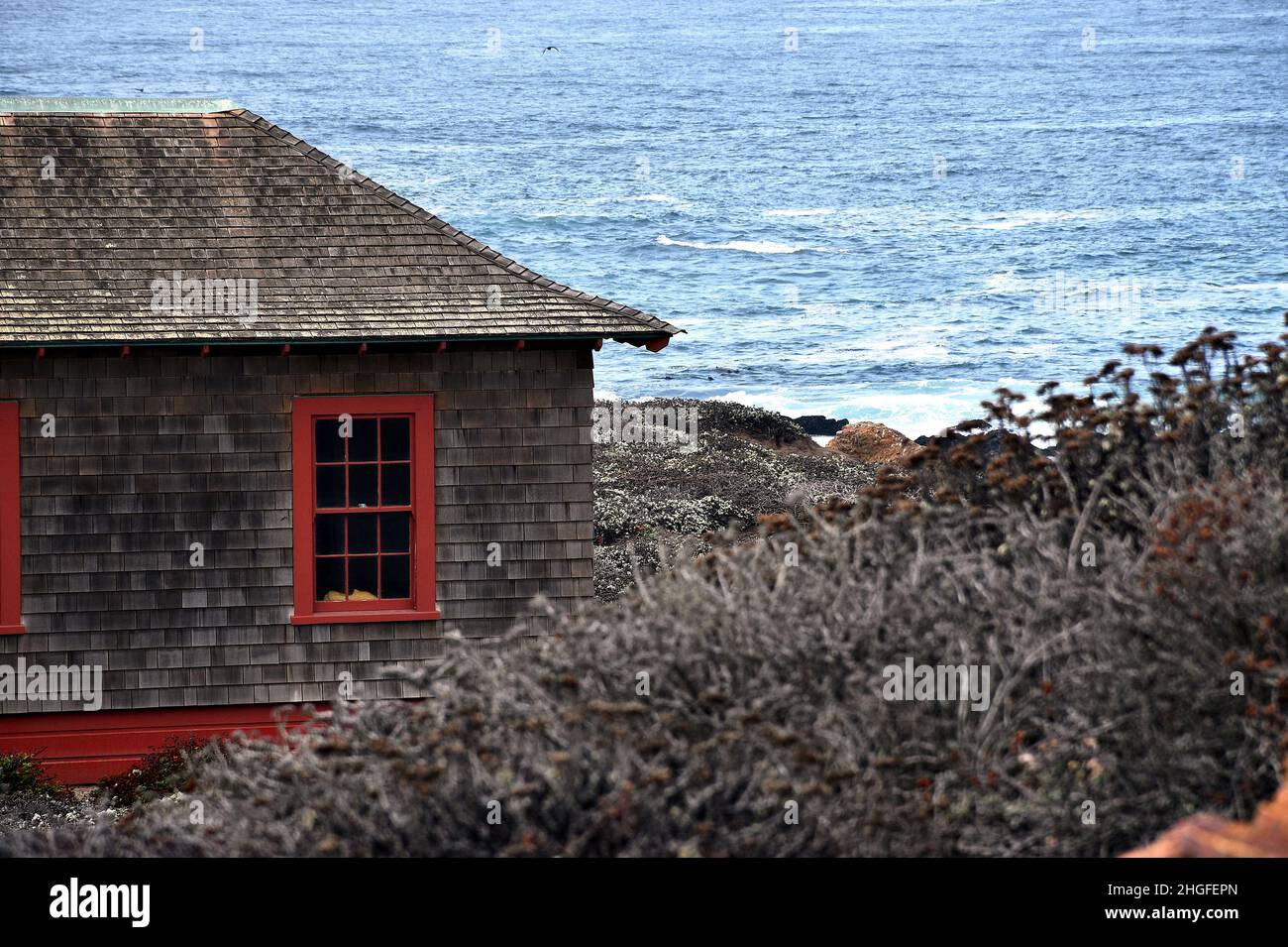 Cottage con scandole sul mare con Oceano Blu e vegetazione Foto Stock