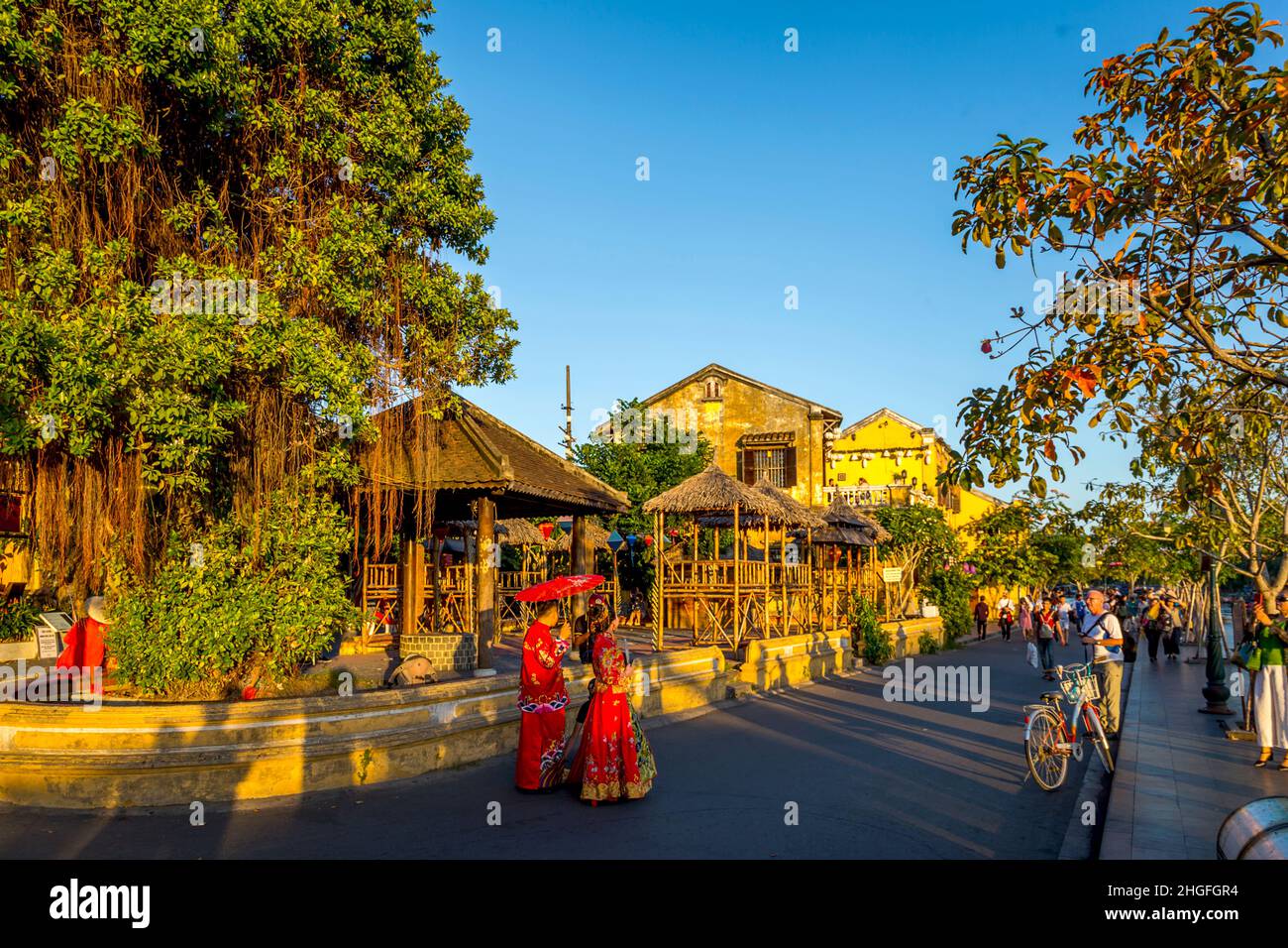 Strada chiusa vicino al fiume con alcune persone durante il tramonto nella Città Vecchia, Hoi An. Foto Stock